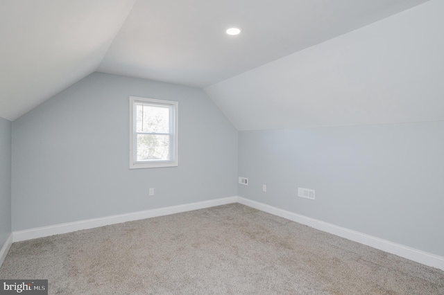 additional living space with light carpet and vaulted ceiling