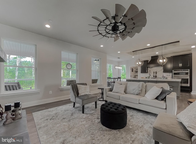 living room with dark hardwood / wood-style floors, a healthy amount of sunlight, and ceiling fan