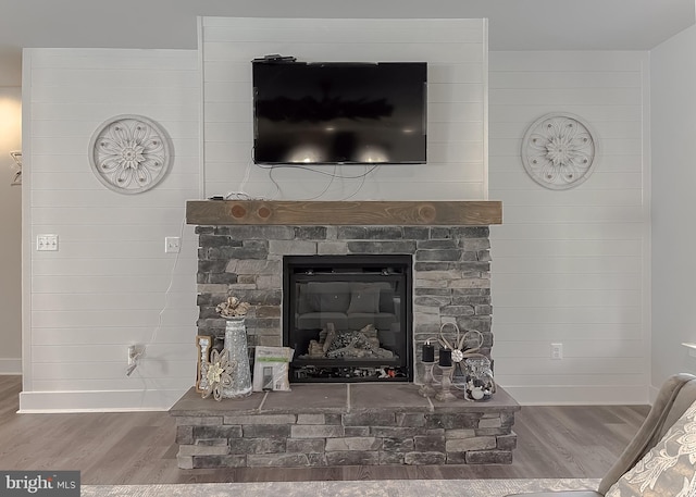 interior details featuring hardwood / wood-style flooring and a stone fireplace