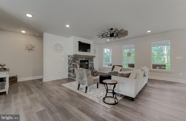 living room featuring hardwood / wood-style floors, a fireplace, and ceiling fan