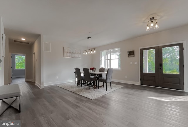 dining space featuring hardwood / wood-style floors, a notable chandelier, and french doors