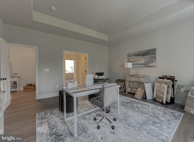 office featuring dark hardwood / wood-style floors and a raised ceiling