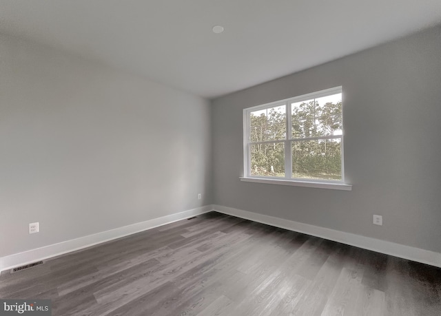 unfurnished room with dark wood-type flooring