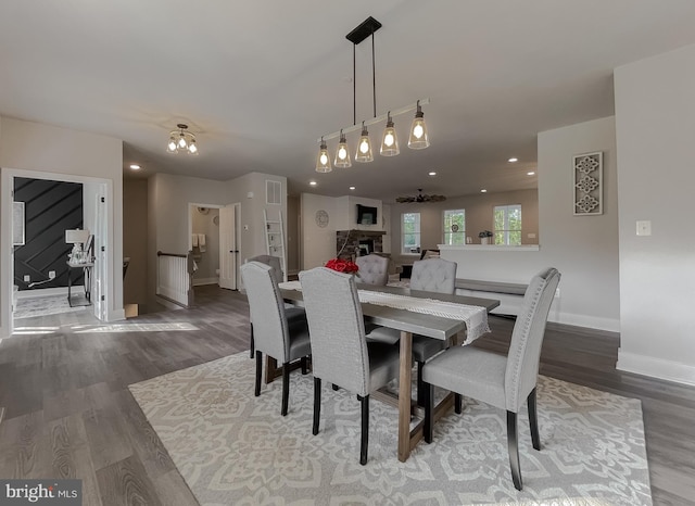 dining space with hardwood / wood-style flooring and a stone fireplace