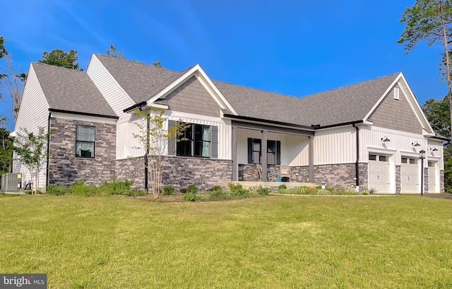 view of front of home with a garage, covered porch, a front lawn, and central air condition unit