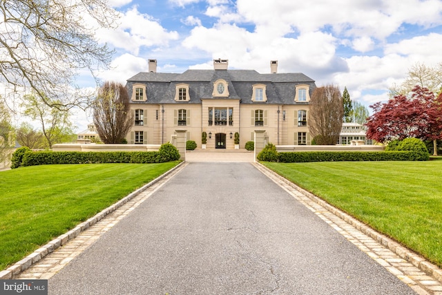 french country style house with a front lawn