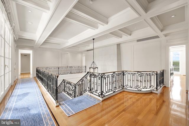 hall with ornamental molding, coffered ceiling, and beam ceiling