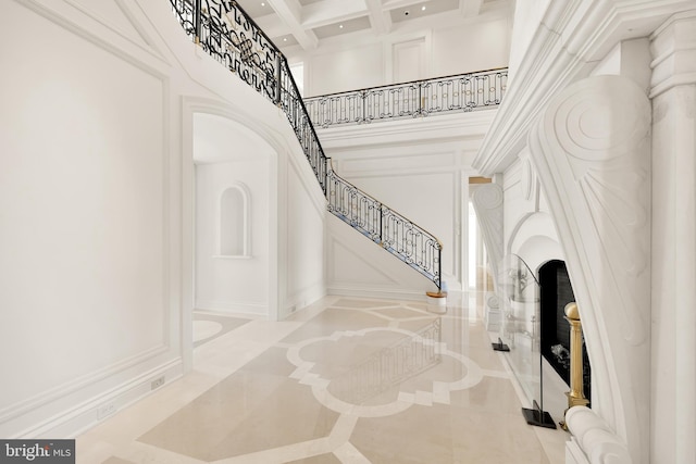 entrance foyer featuring a high ceiling, coffered ceiling, and beam ceiling