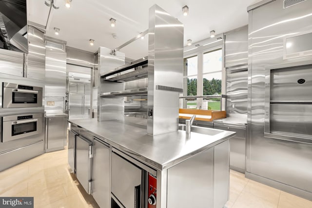 kitchen with stainless steel counters, a center island, light tile patterned floors, and exhaust hood