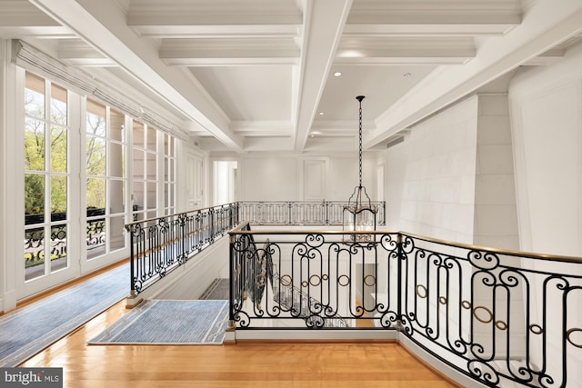 hallway with coffered ceiling, beam ceiling, crown molding, and hardwood / wood-style flooring