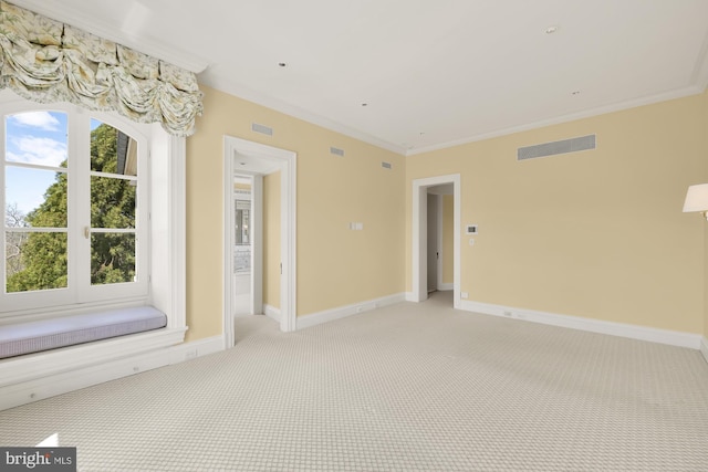 empty room featuring crown molding and light carpet