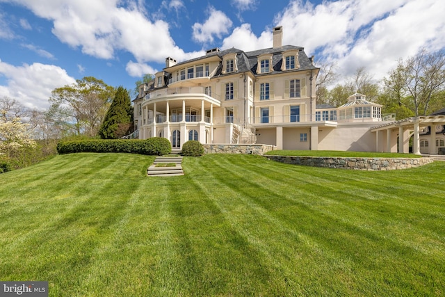 rear view of property with a lawn