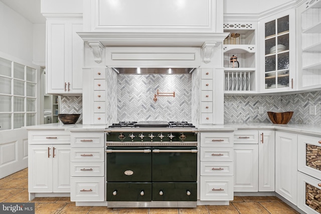 kitchen with white cabinets, backsplash, and high end stainless steel range oven