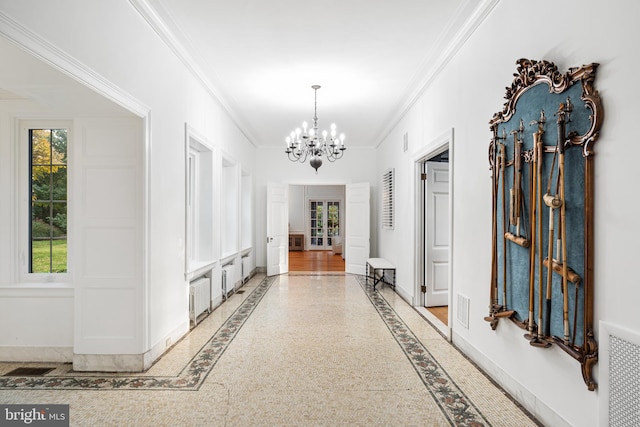 hall featuring ornamental molding and an inviting chandelier