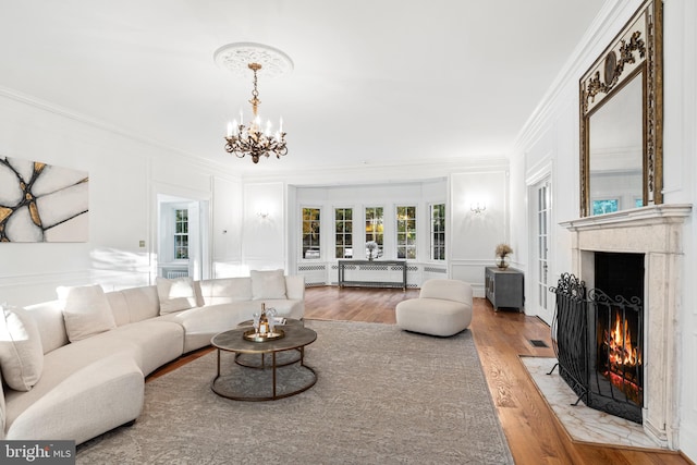 living room featuring crown molding, a chandelier, and hardwood / wood-style floors