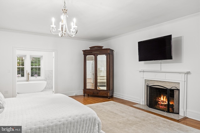 bedroom with ornamental molding, light wood-type flooring, and a high end fireplace