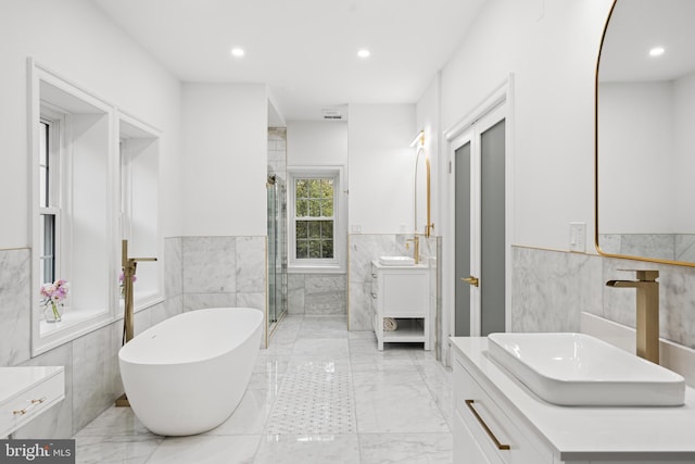 bathroom with vanity, tile walls, and plus walk in shower