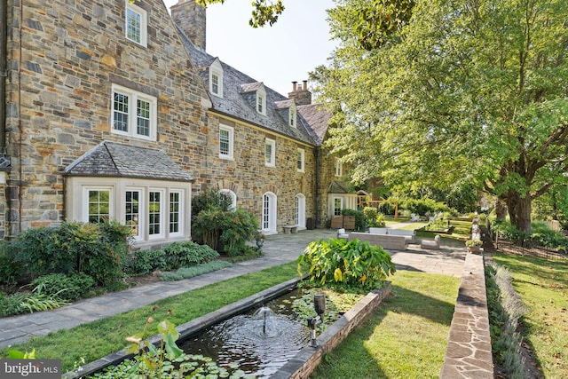 rear view of house with french doors, a yard, and a patio area