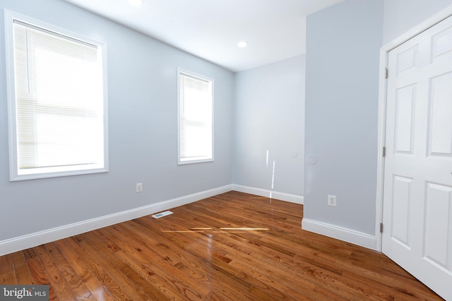 unfurnished room featuring dark hardwood / wood-style floors and a wealth of natural light