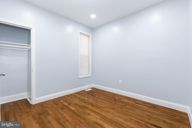 unfurnished bedroom featuring a closet and dark hardwood / wood-style floors