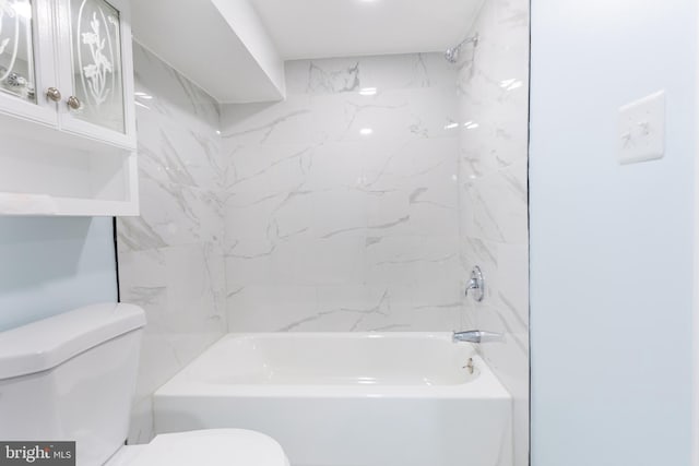 bathroom featuring toilet and tiled shower / bath