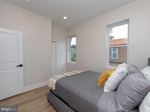 bedroom with light wood-type flooring and a closet