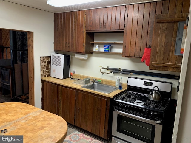 kitchen with dark brown cabinetry, stainless steel gas stove, and sink