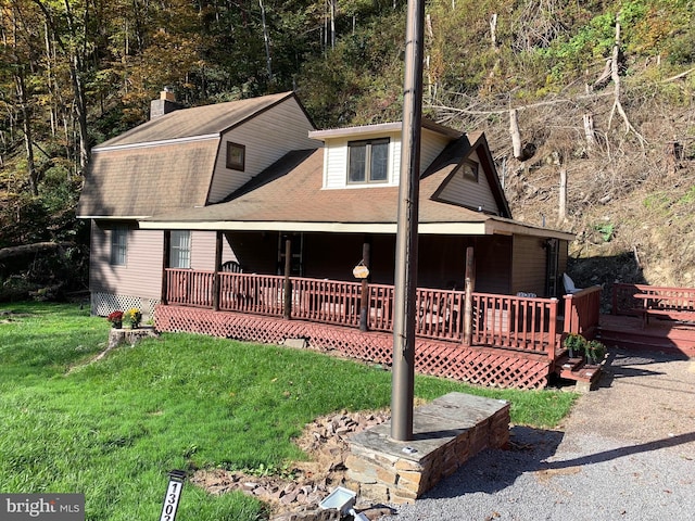 view of front of home with a wooden deck and a front yard