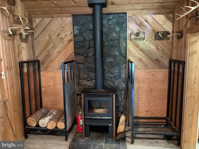 interior space featuring dark hardwood / wood-style flooring, wooden walls, and a wood stove