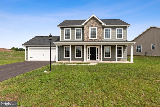 view of front of property with a garage, covered porch, and a front lawn