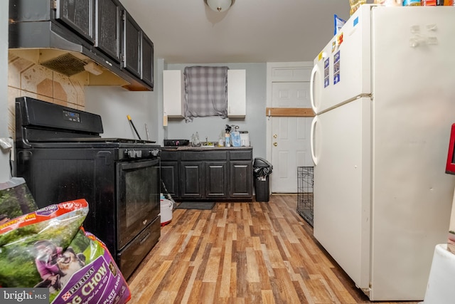 kitchen featuring black range oven, light hardwood / wood-style floors, sink, and white fridge