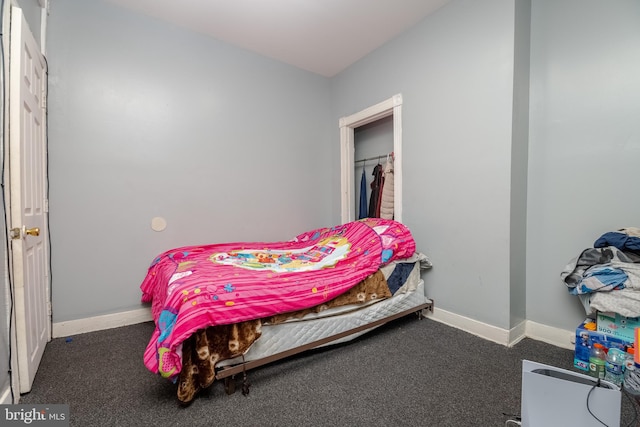 bedroom with a closet and dark colored carpet