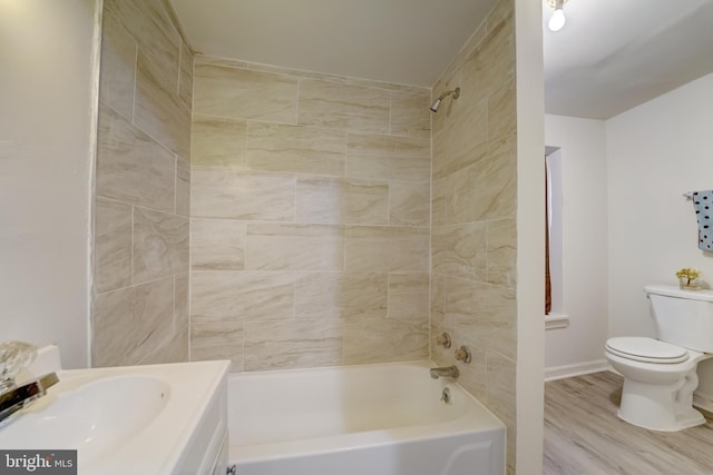 full bathroom featuring tiled shower / bath combo, toilet, vanity, and hardwood / wood-style flooring