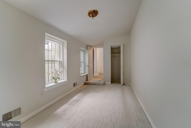 unfurnished bedroom featuring a closet and multiple windows