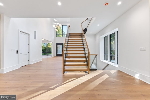 staircase with a notable chandelier and hardwood / wood-style floors