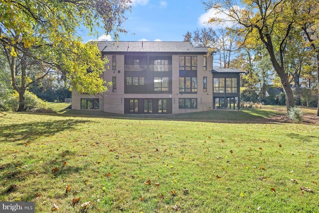 back of property with a sunroom and a yard