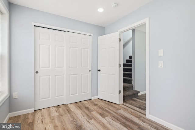 unfurnished bedroom featuring light hardwood / wood-style flooring and a closet