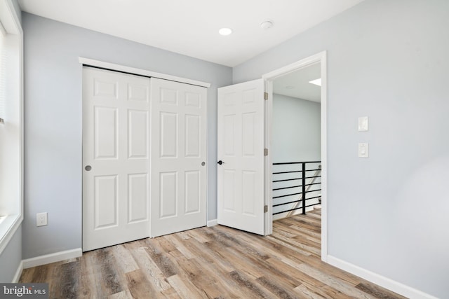 unfurnished bedroom featuring a closet and light wood-type flooring