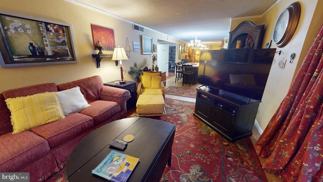 living room with dark wood-type flooring, ornamental molding, a textured ceiling, and a chandelier