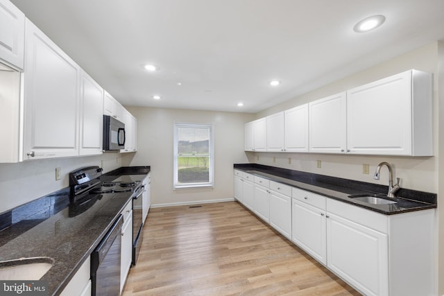 kitchen with white cabinetry, black appliances, sink, and light wood-type flooring