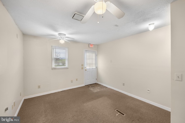 carpeted spare room with a textured ceiling and ceiling fan