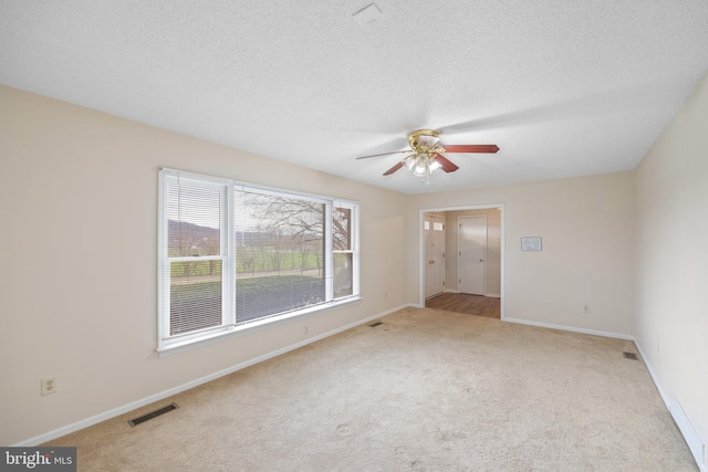 carpeted empty room featuring a textured ceiling and ceiling fan