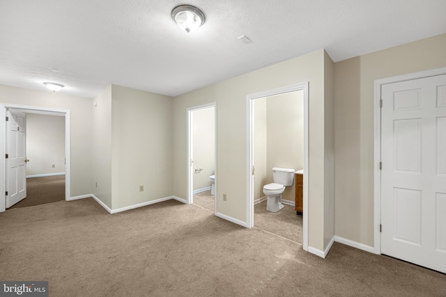 unfurnished bedroom with light colored carpet and ensuite bathroom