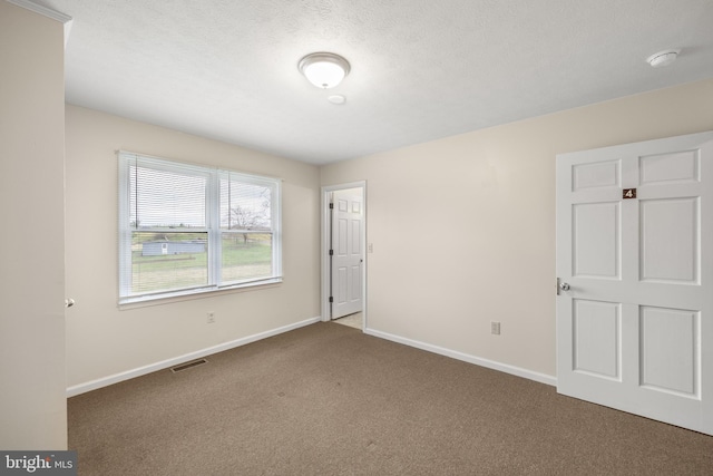 spare room featuring dark colored carpet