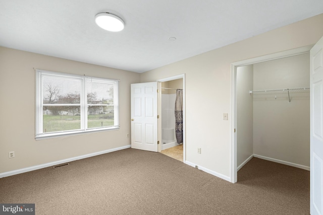 unfurnished bedroom with light carpet, ensuite bath, and a closet