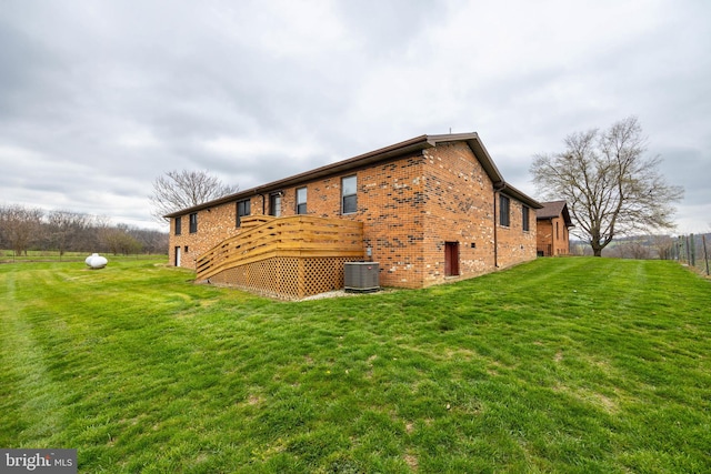 back of property featuring a lawn and central AC unit