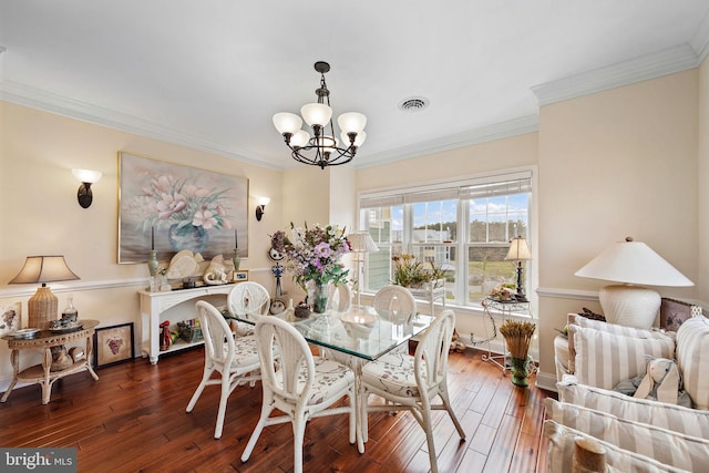 dining room with a notable chandelier, ornamental molding, and dark hardwood / wood-style floors