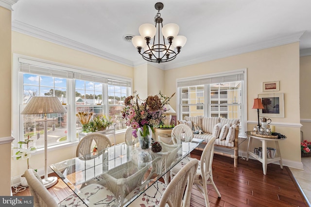 dining space featuring an inviting chandelier, crown molding, and dark hardwood / wood-style flooring