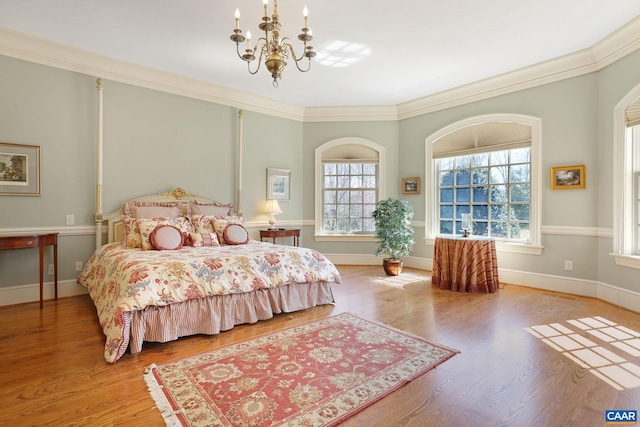 bedroom featuring crown molding, light wood-type flooring, a chandelier, and multiple windows