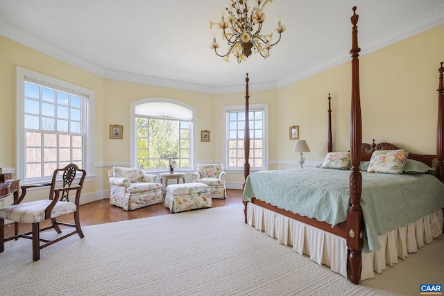 bedroom with light hardwood / wood-style floors, ornamental molding, and an inviting chandelier